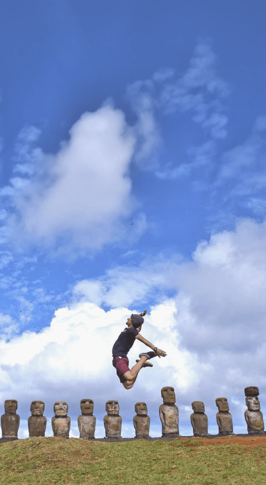モアイ像の前でジャンプしている人